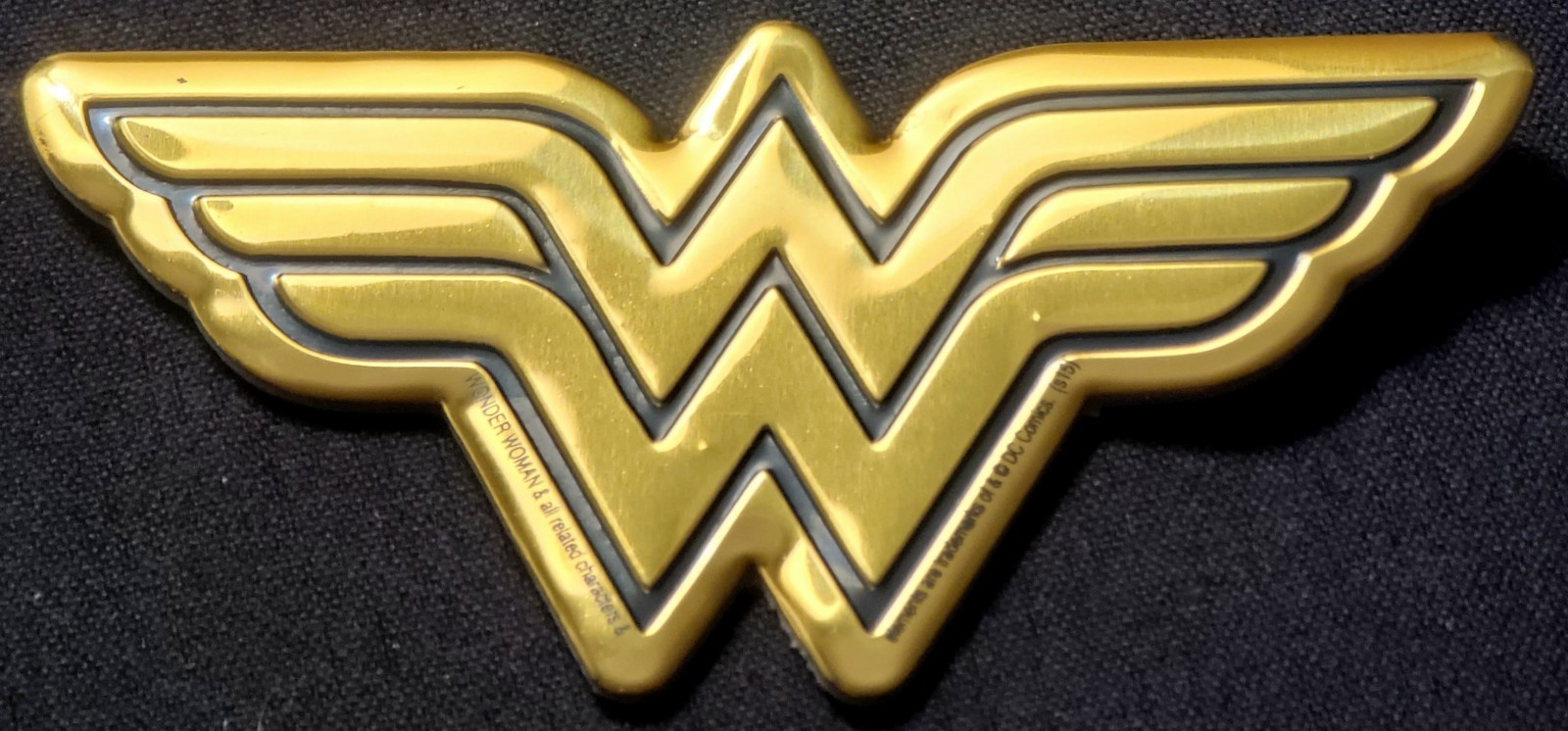 WONDER WOMAN METAL STICKER 3 1/2 X 2″ BLACK & GOLD. HAS A GREAT GOLD SHINE TO IT